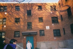 Two children standing in front of public housing building